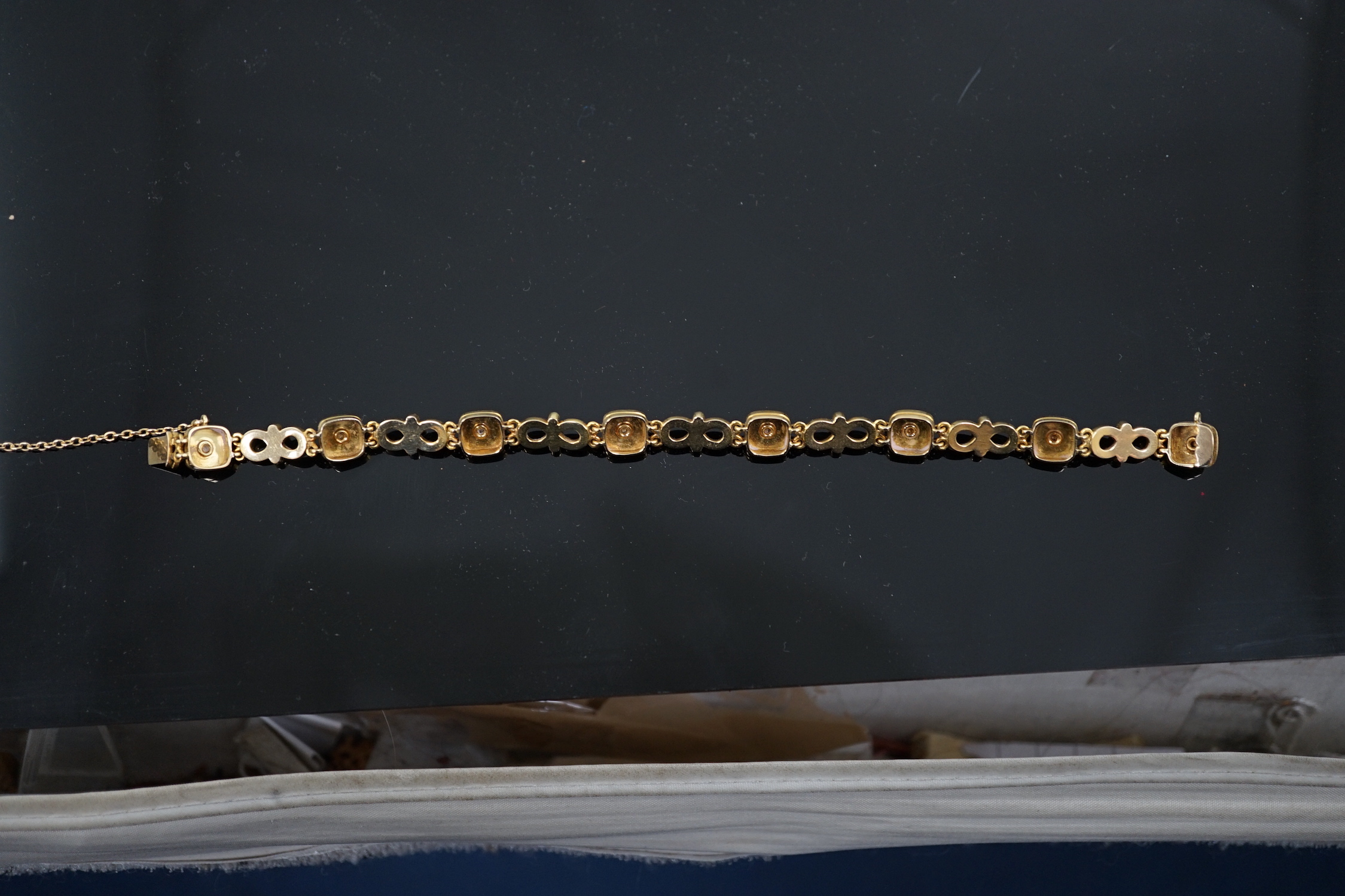An early 20th century gold (tests as 18ct), two colour enamel and spilt pearl set bracelet